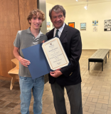 Rep. Latimer with winner Joseph standing in an art gallery setting