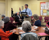 Rep. Latimer speaking in front of a group of people in a cafeteria setting